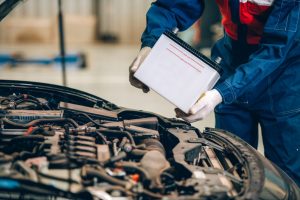 A mechanic replacing a Nissan's car battery near Fishers, Indiana