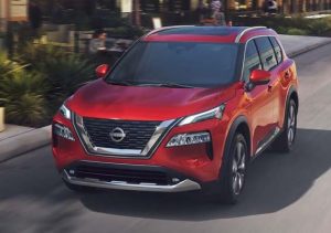 A red 2023 Nissan Rogue driving down a neighborhood street near Fishers, Indiana.