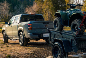 A 2023 Nissna Frontier towing an ATV on a dirt road near Fishers, Indiana.