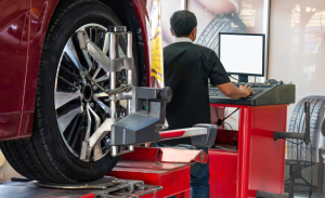 A service technician performing a tire alignment near Fishers, Indiana