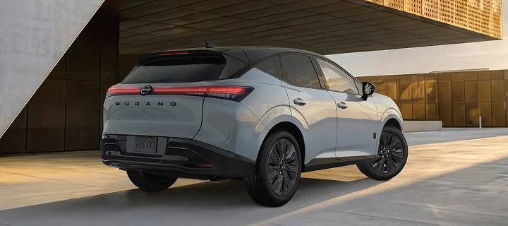 Rear view of a silver 2026 Nissan Murano parked outside a modern building