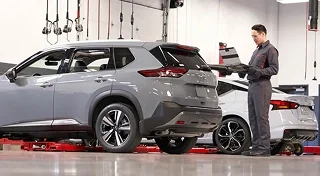Nissan technician inspecting a Nissan Rogue in the service bay